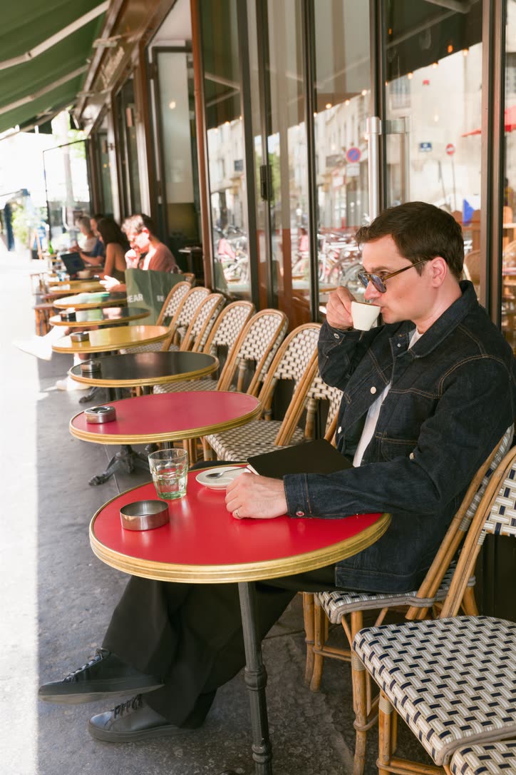 A Paris café terrace in the late morning, chairs turned out to the street